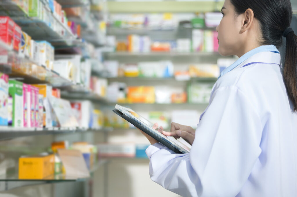 A Portrait of female pharmacist using tablet in a modern pharmacy drugstore.