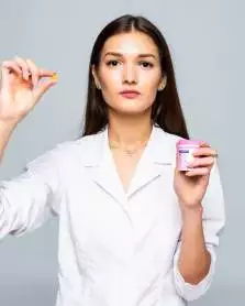 Long-term care pharmacist, holding a small medication bottle